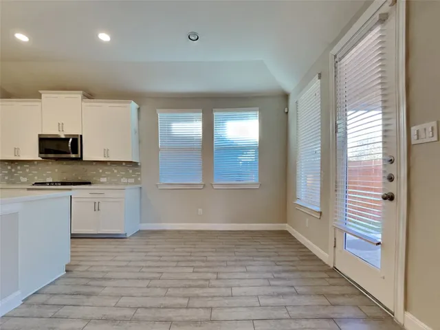 a large white kitchen with granite countertop a stove and a sink