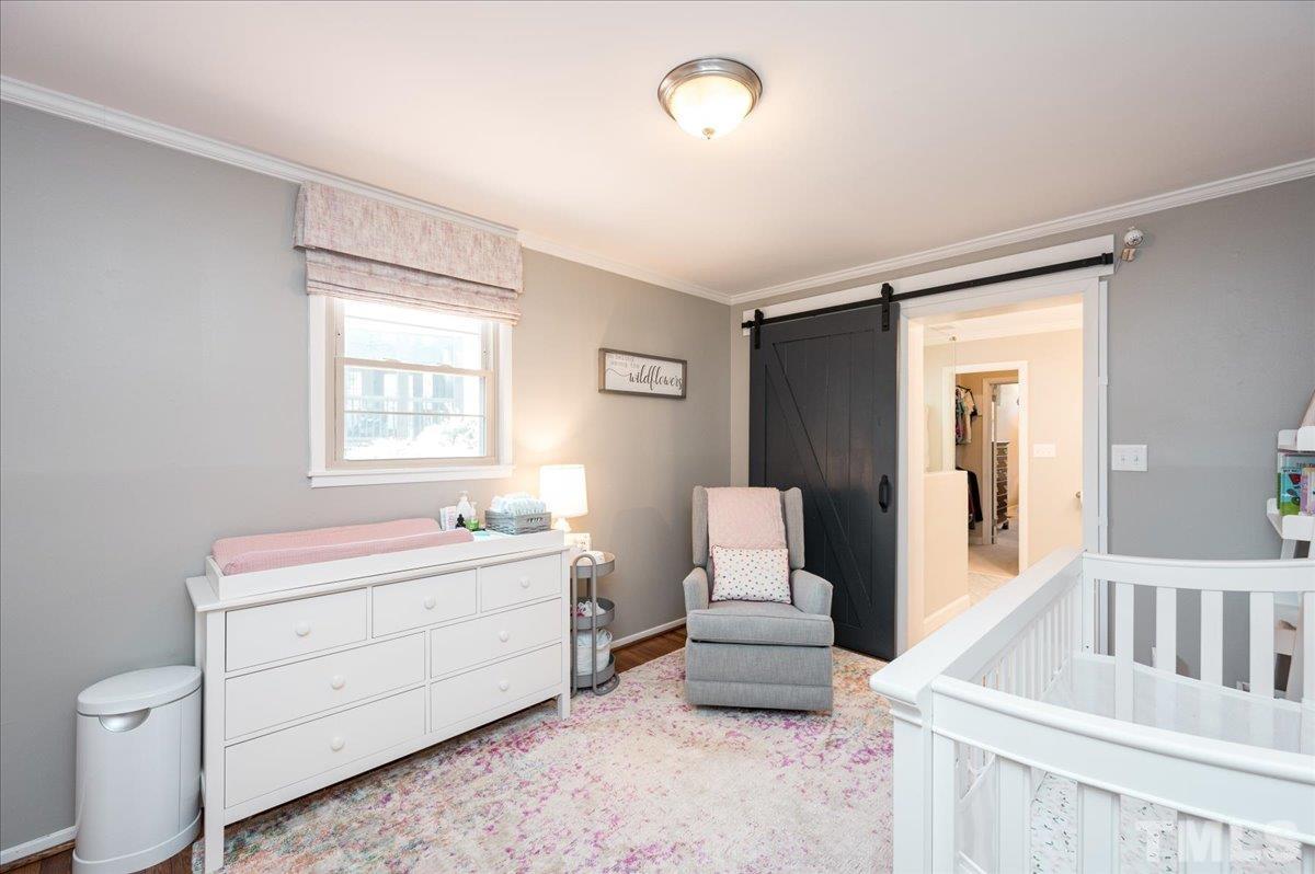 3426 Redbud Lane Raleigh, NC 27607 - Photo 20 of 30 a living room with furniture and a baby crib