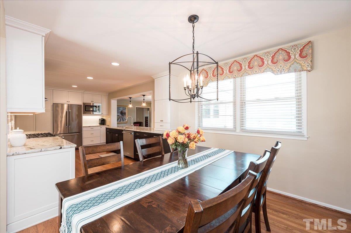 3426 Redbud Lane Raleigh, NC 27607 - Photo 5 of 30 a dining room with furniture a chandelier and wooden floor