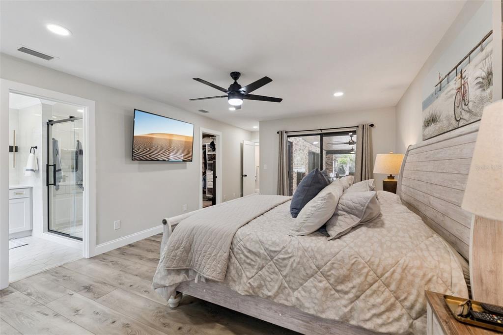 1908 Poppy Lane Port Orange, FL 32128 - Photo 14 of 43 a bedroom with a large bed a flat tv screen and a walk in closet