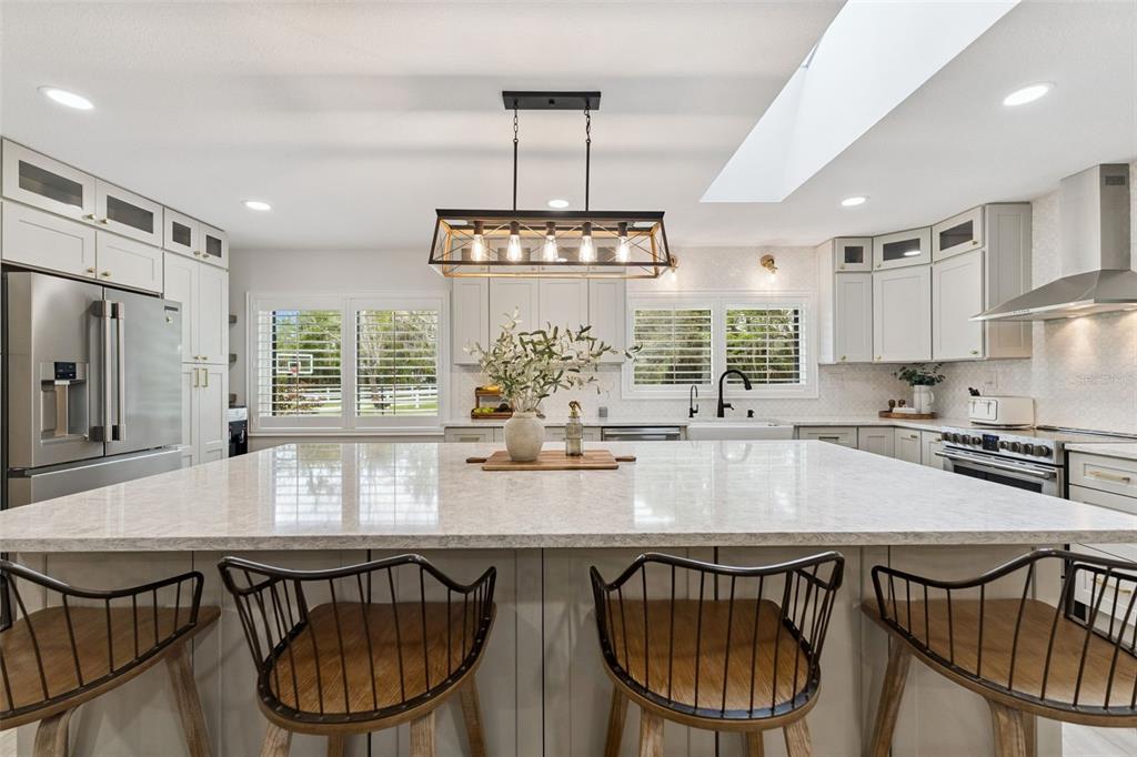 1908 Poppy Lane Port Orange, FL 32128 - Photo 10 of 43 a kitchen with kitchen island granite countertop a table chairs stove and refrigerator