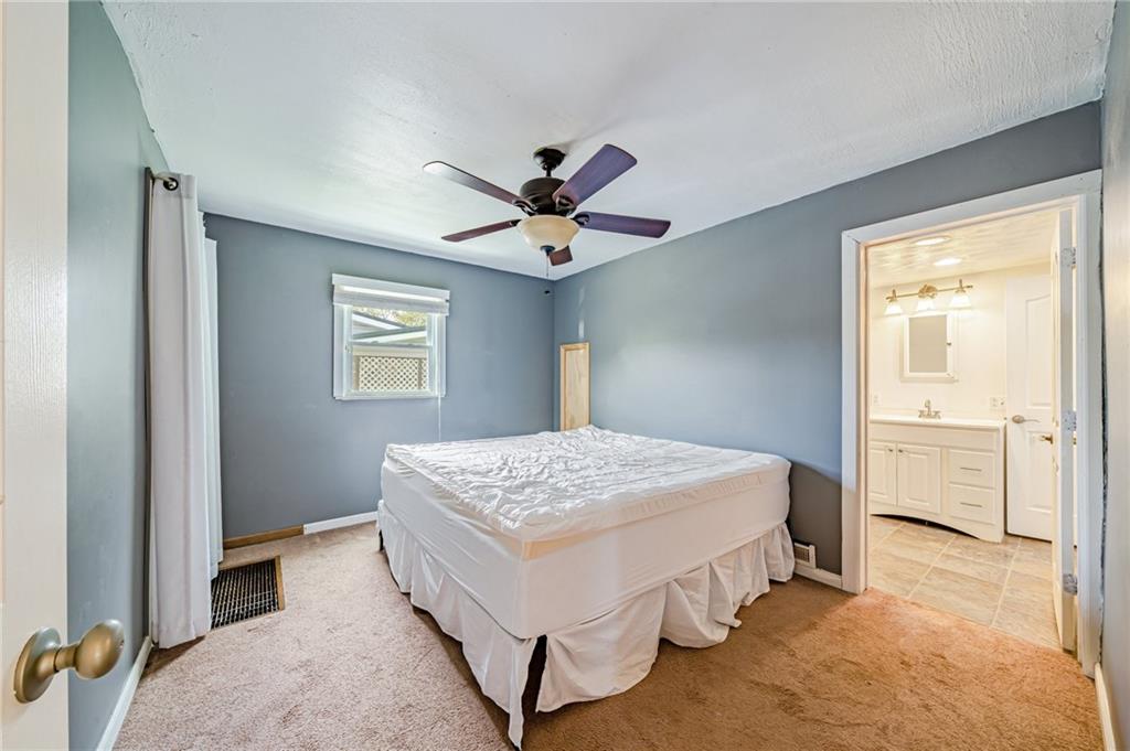 135 Elrico Road Slickville, PA 15684 - Photo 12 of 22 a spacious bedroom with a bed and a chandelier