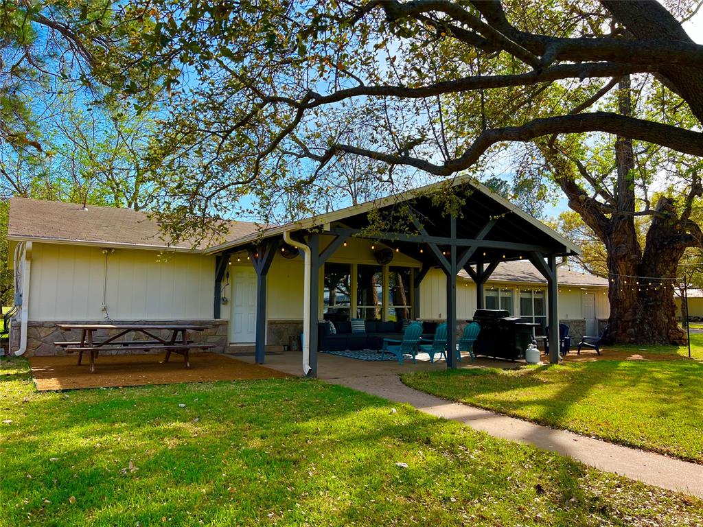 1957 Deer Trail Road Graford, TX 76449 - Photo 4 of 32 a view of a swimming pool with lawn chairs under an umbrella