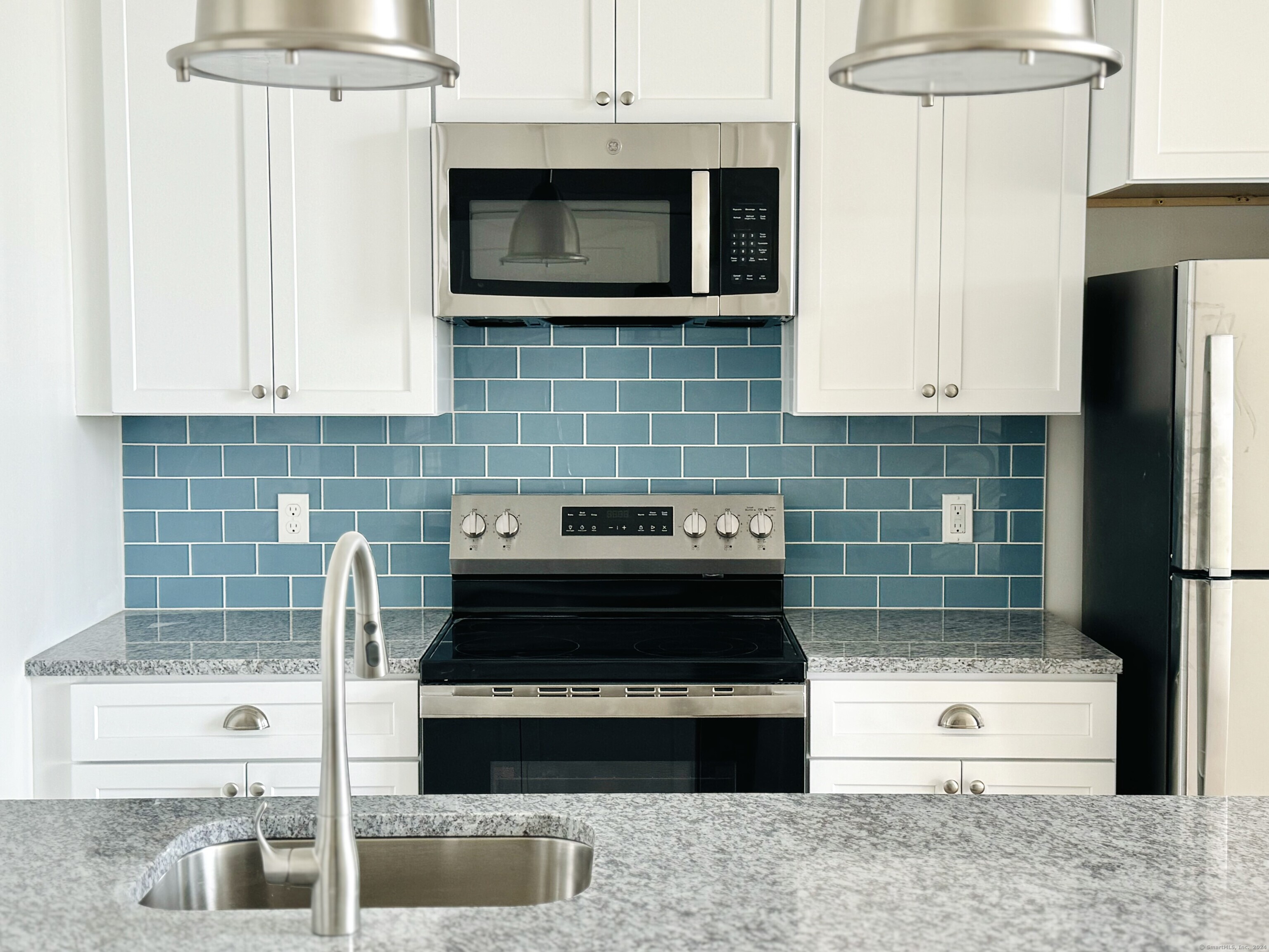 50 Perkins Farm Drive, Unit PH402 NEWPORT Stonington, CT 06355 - Photo 13 of 31 a kitchen with granite countertop a stove and a microwave