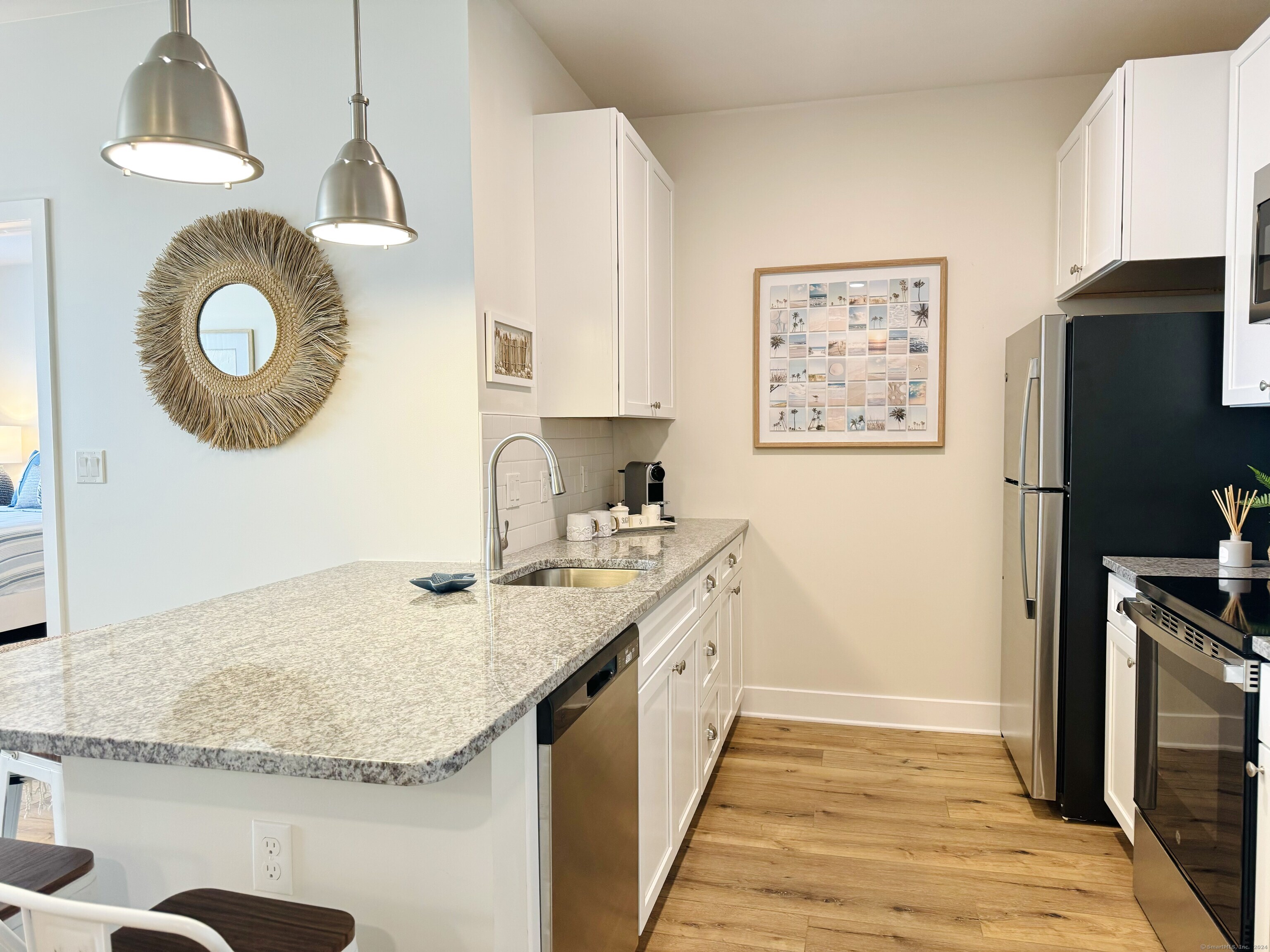 50 Perkins Farm Drive, Unit PH402 NEWPORT Stonington, CT 06355 - Photo 17 of 31 a kitchen with kitchen island granite countertop a sink a stove refrigerator and microwave