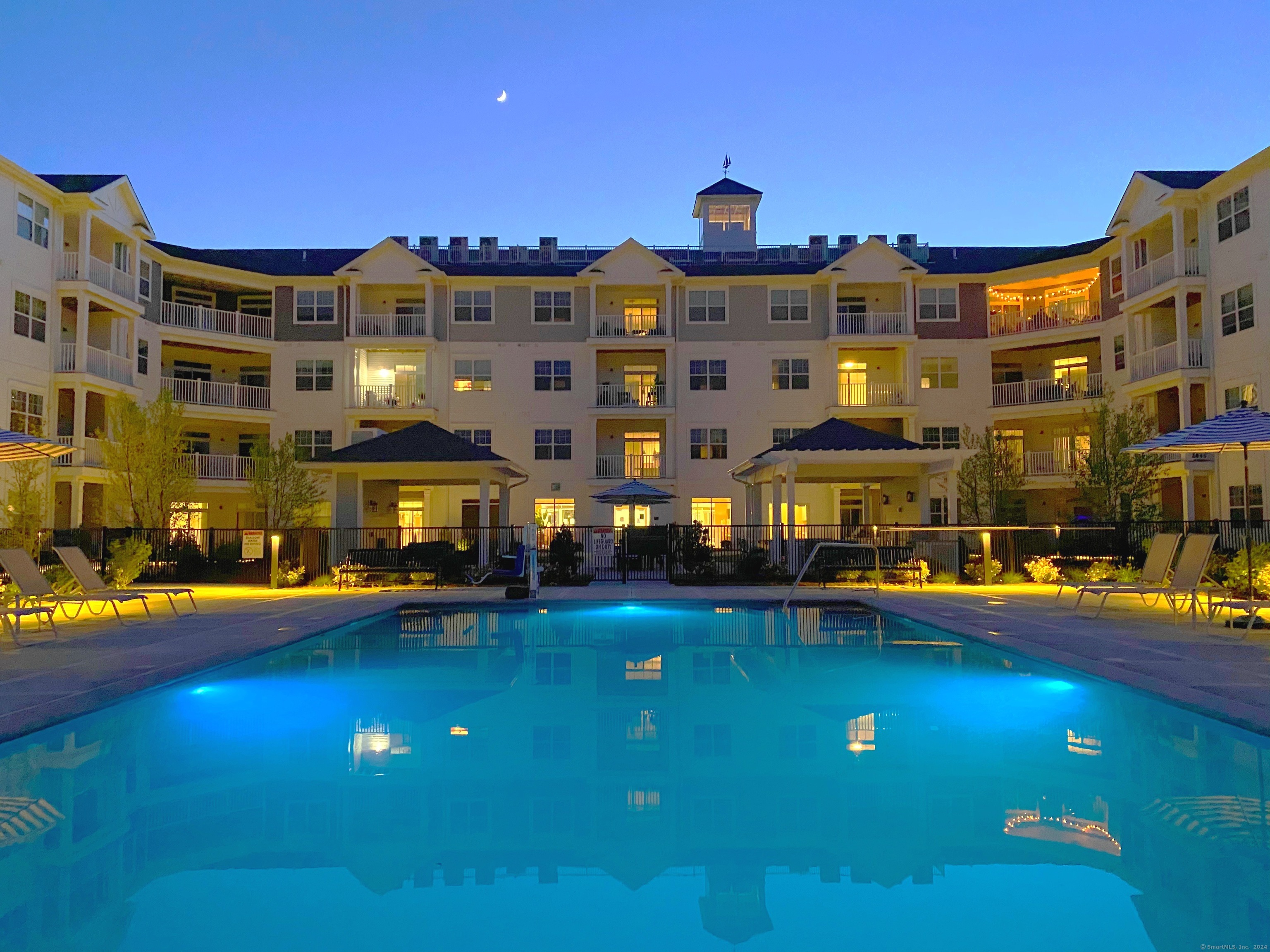 50 Perkins Farm Drive, Unit PH402 NEWPORT Stonington, CT 06355 - Photo 4 of 31 a building with swimming pool and tall buildings in the background