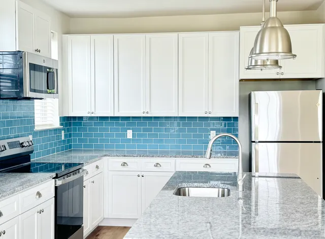 a kitchen with stainless steel appliances granite countertop a sink a stove and a microwave oven