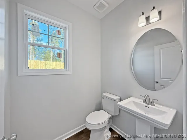 a bathroom with a toilet a sink and mirror