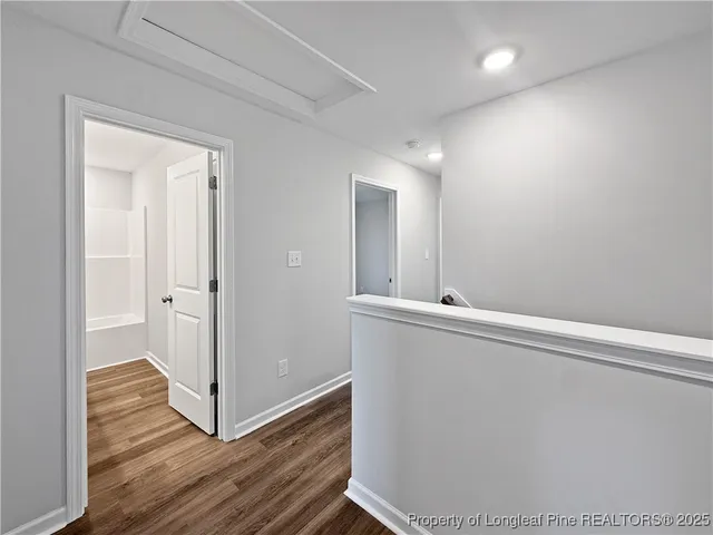 a view of a hallway with wooden floor