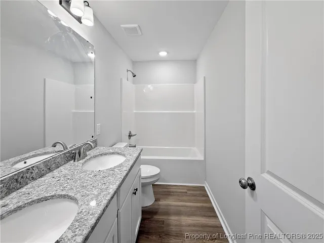 a bathroom with a granite countertop sink a mirror and a bathtub