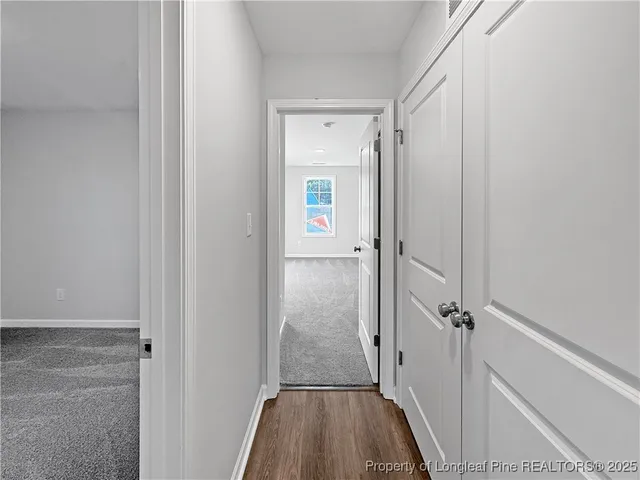 a view of a hallway with wooden floor and closet area