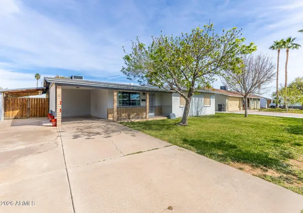a front view of a house with a garden and trees