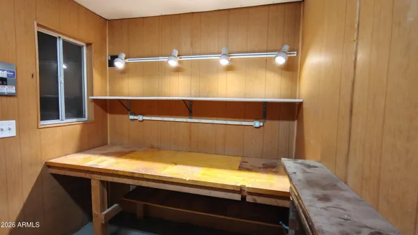 a backyard of a house with table and chairs under an umbrella