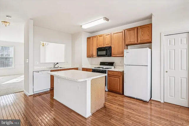 a kitchen with a refrigerator a stove top oven and a refrigerator