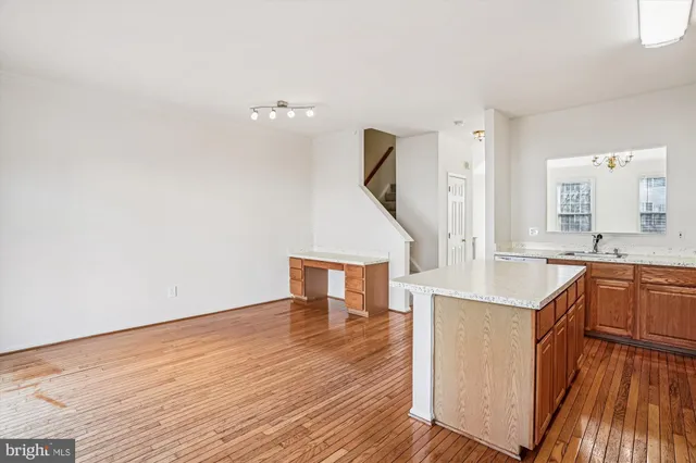 a kitchen with stainless steel appliances granite countertop a sink a stove and a wooden floors