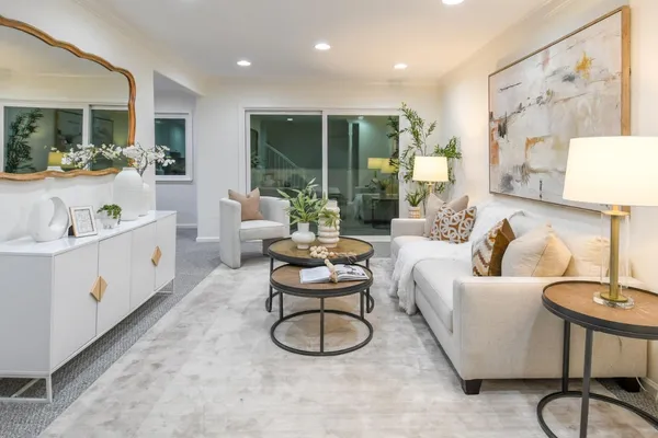 a living room with furniture a large window and gym equipment