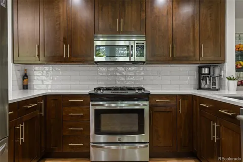 a kitchen with granite countertop wood cabinets and stainless steel appliances