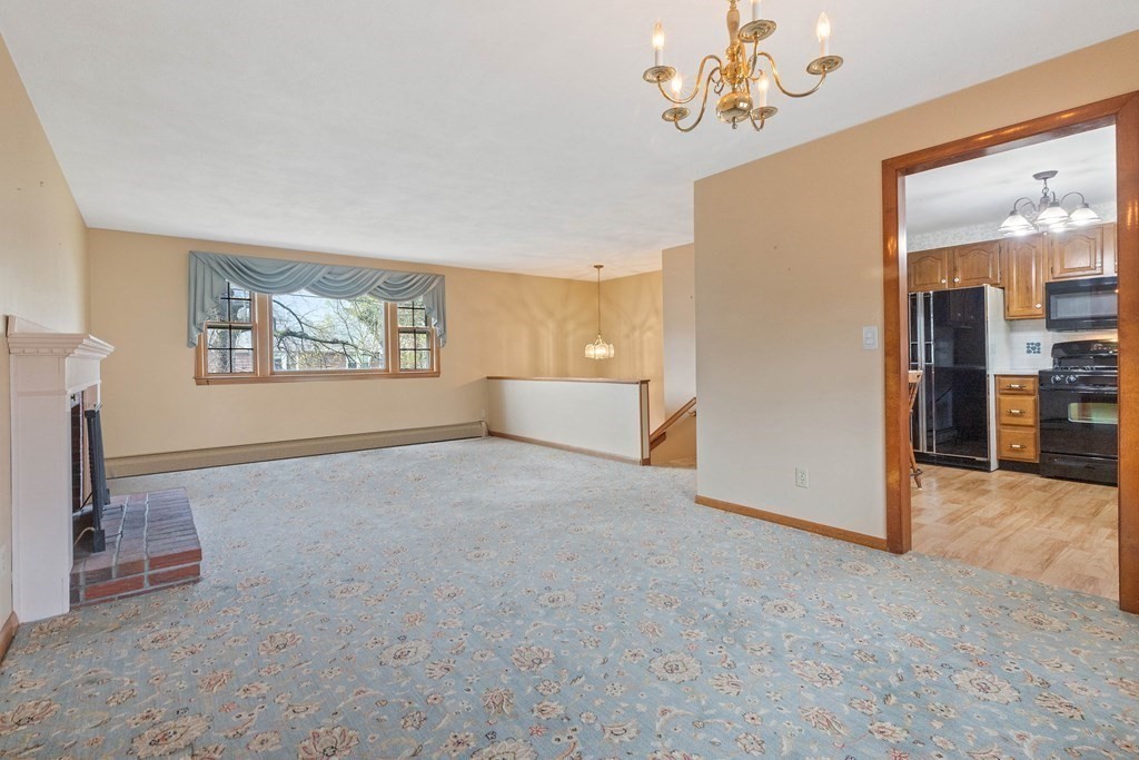 29 Taft Avenue Beverly, MA 01915 - Photo 7 of 41 an empty room with windows chandelier and fireplace