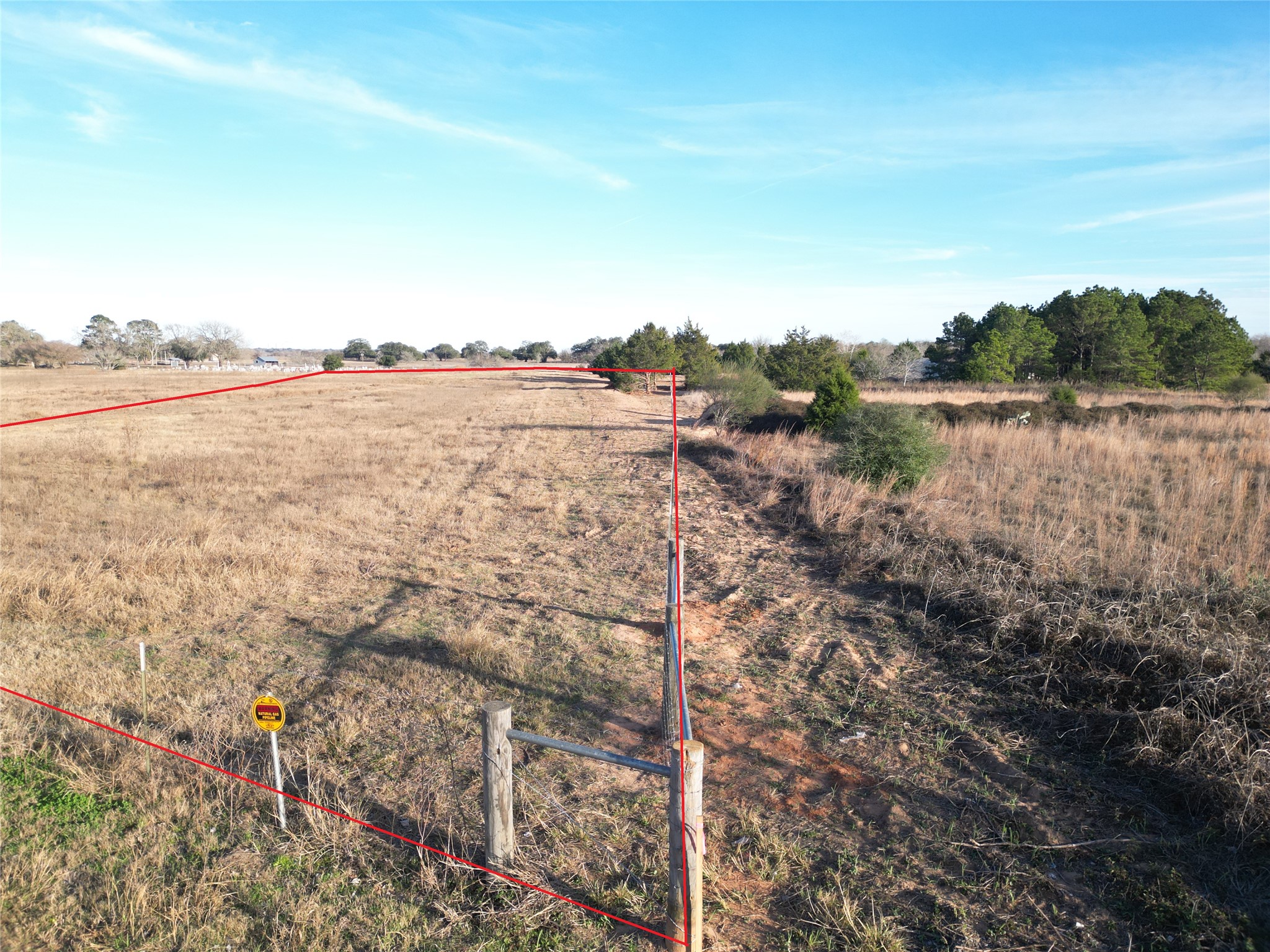 4 Trinity School Road La Grange, TX 78945 - Photo 9 of 11 Vast open acreage bordered by trees under a clear blue sky offers endless possibilities.