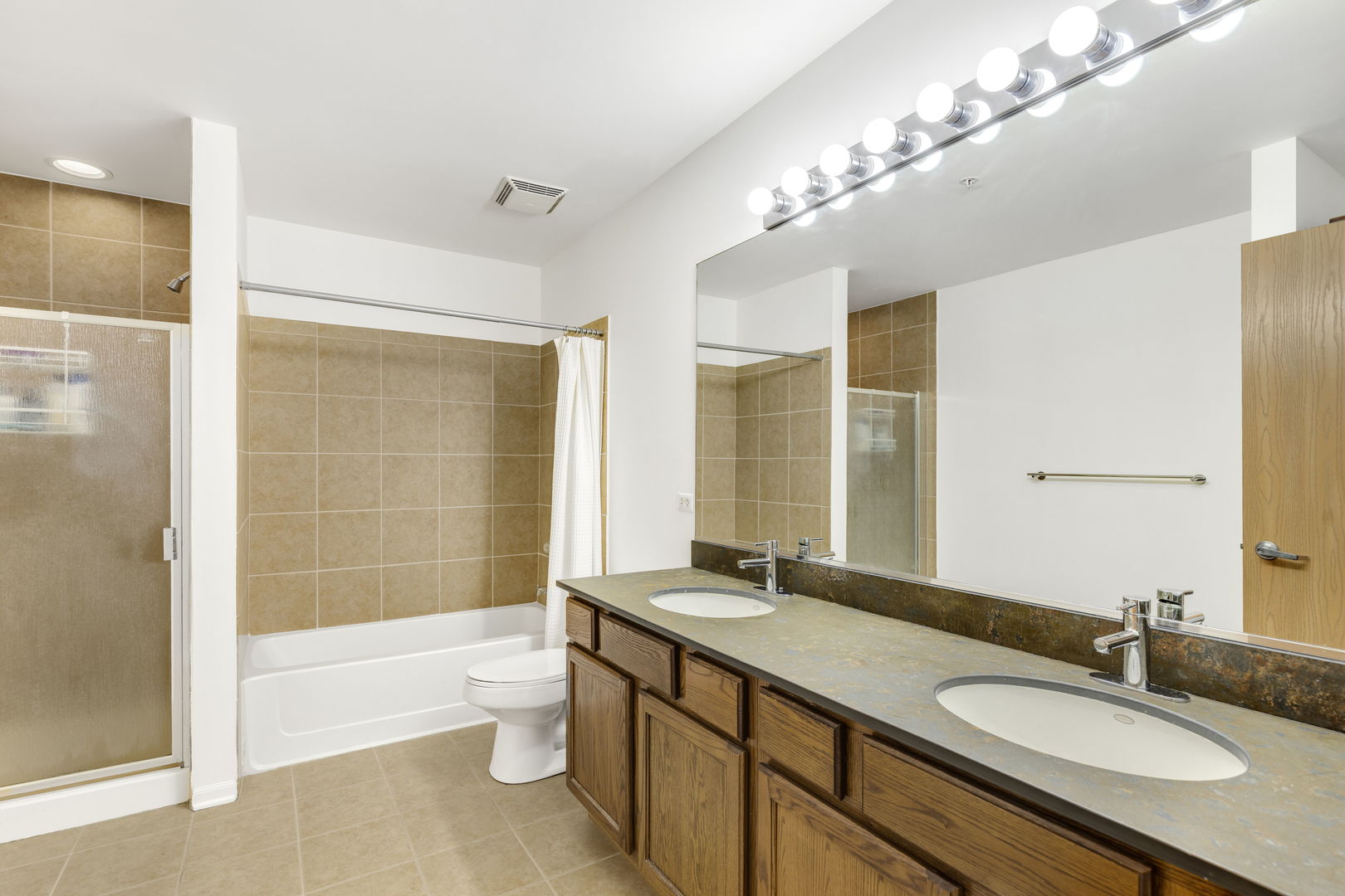 515 Main Street, Unit 308 Evanston, IL 60202 - Photo 13 of 19 a bathroom with a granite countertop double vanity sink a toilet and shower