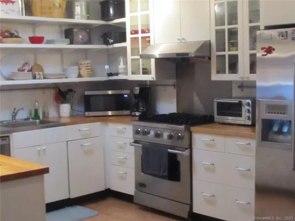 a kitchen with stainless steel appliances granite countertop white cabinets and a stove