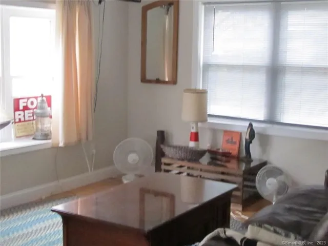 a view of a small living room with a sink and a mirror