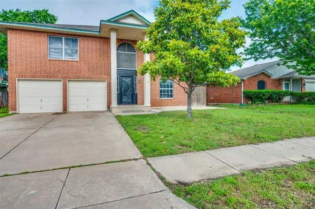 a front view of a house with a yard and a garage