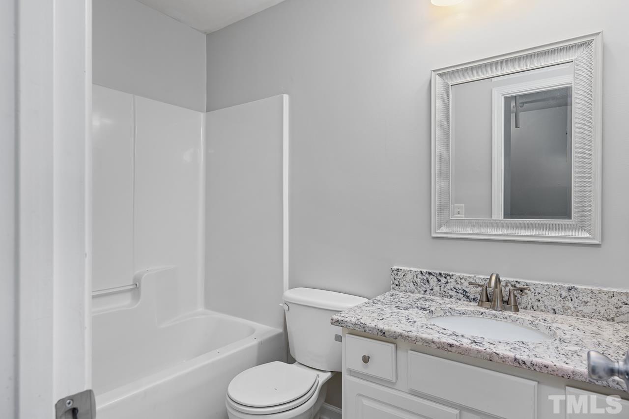 4422 Vienna Crest Drive Raleigh, NC 27613 - Photo 19 of 28 a bathroom with a granite countertop sink toilet and mirror