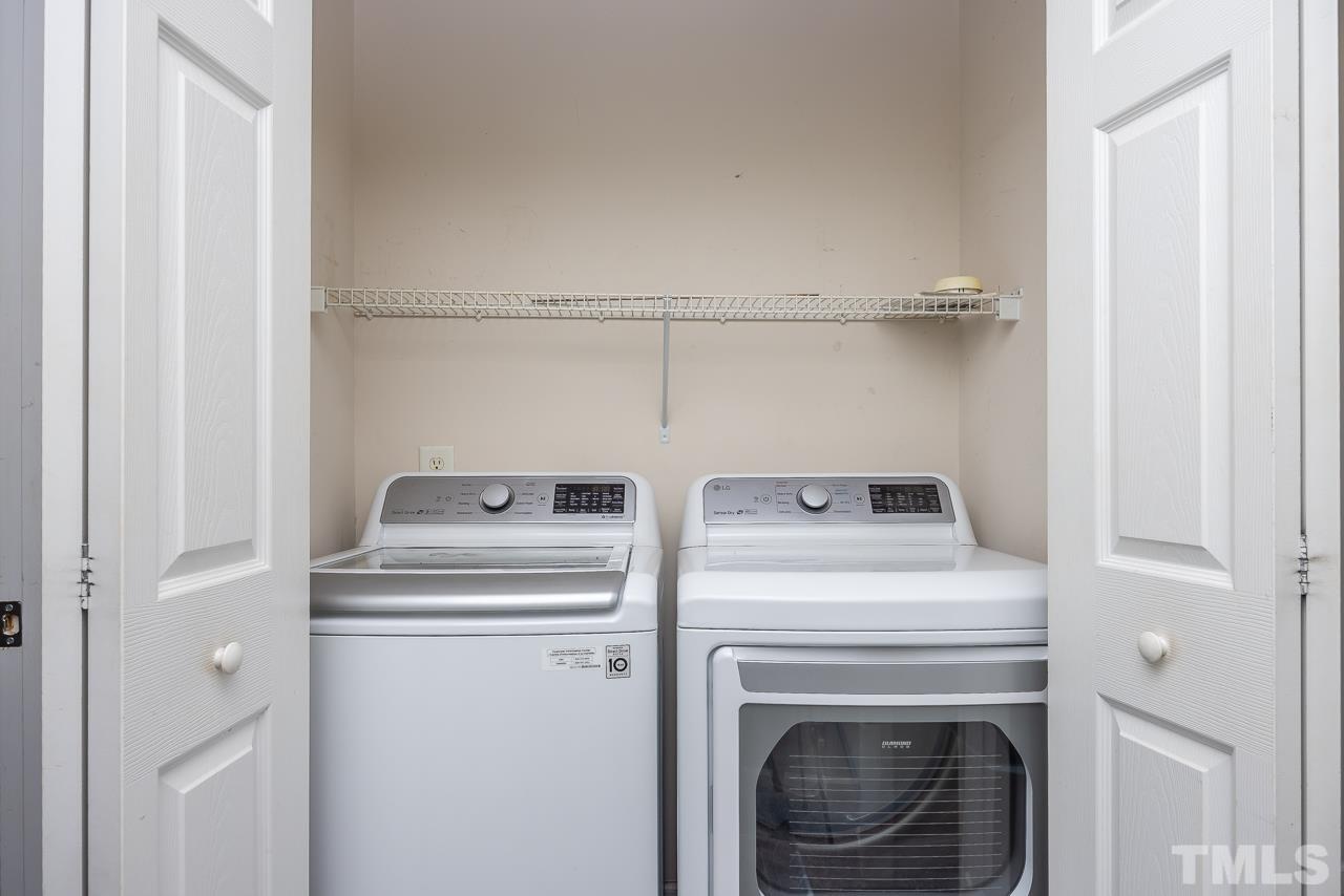 4422 Vienna Crest Drive Raleigh, NC 27613 - Photo 20 of 28 a view of washer and dryer with kitchen in the background