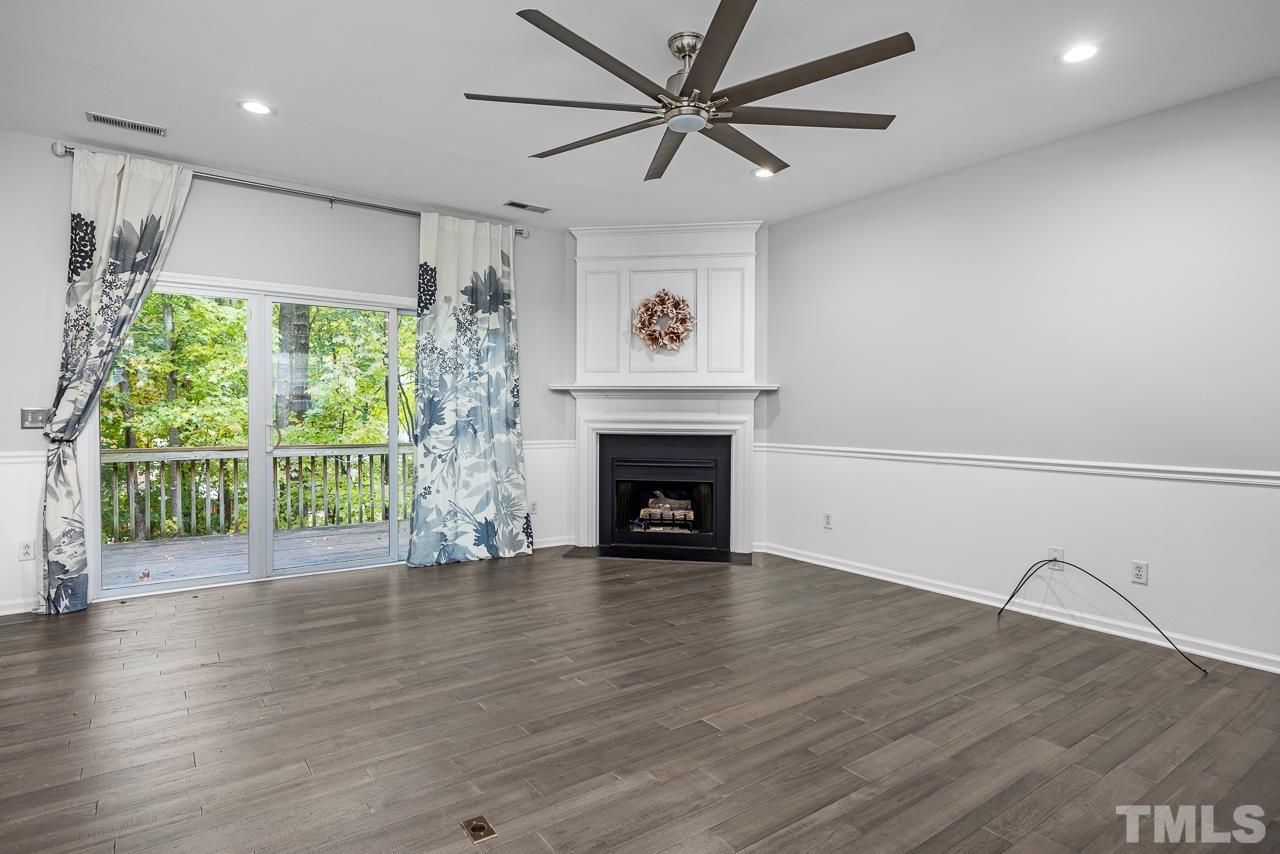 4422 Vienna Crest Drive Raleigh, NC 27613 - Photo 9 of 28 a view of a livingroom with a fireplace a ceiling fan and wooden floor