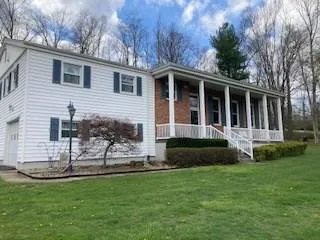 a view of house with backyard and a garden