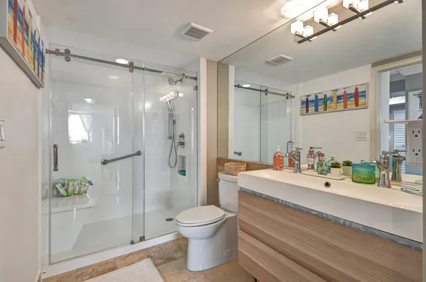 a bathroom with a sink a toilet and shower
