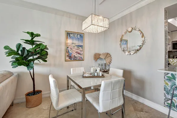 a dining room with furniture a potted plant and a chandelier