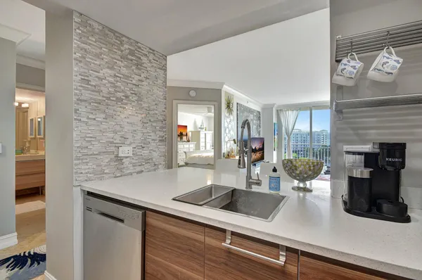 a view of a kitchen with a sink and refrigerator