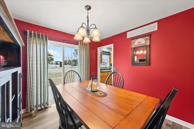 a view of a dining room with furniture a chandelier and wooden floor