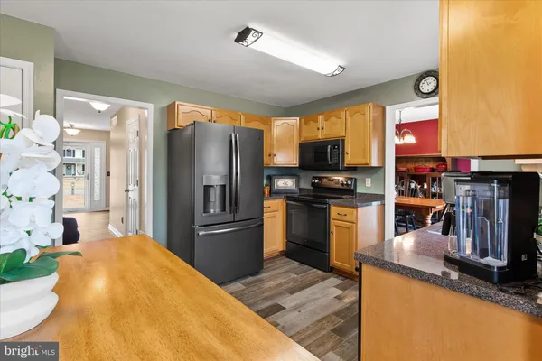 a kitchen with stainless steel appliances granite countertop a refrigerator a stove top oven a sink and dishwasher