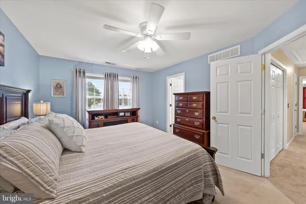 a bedroom with a bed a dresser and a chandelier