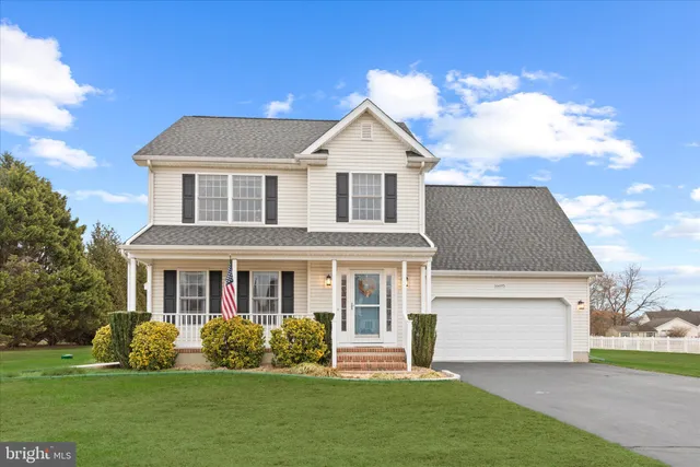 a front view of a house with a garden and yard