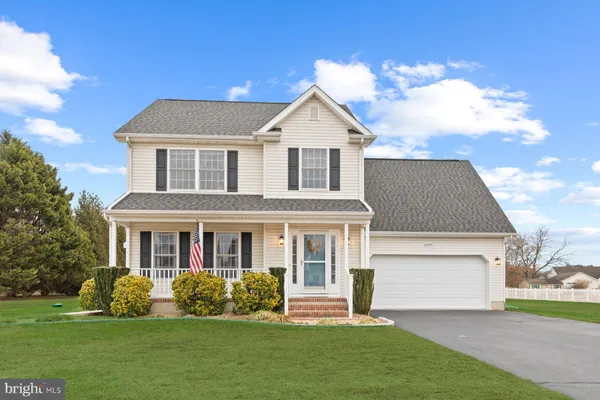 a front view of a house with a garden and yard