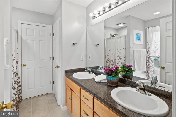 a bathroom with a granite countertop sink a large mirror and a shower