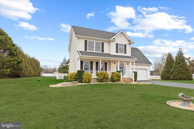 a front view of a house with a yard and trees