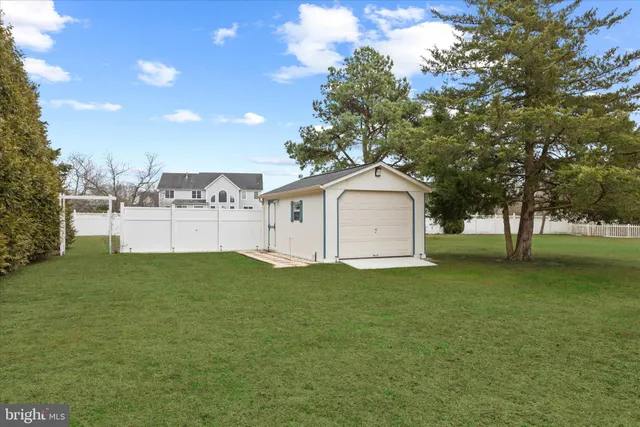 a large white house with a big yard and large trees