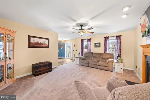 a living room with furniture and ceiling fan