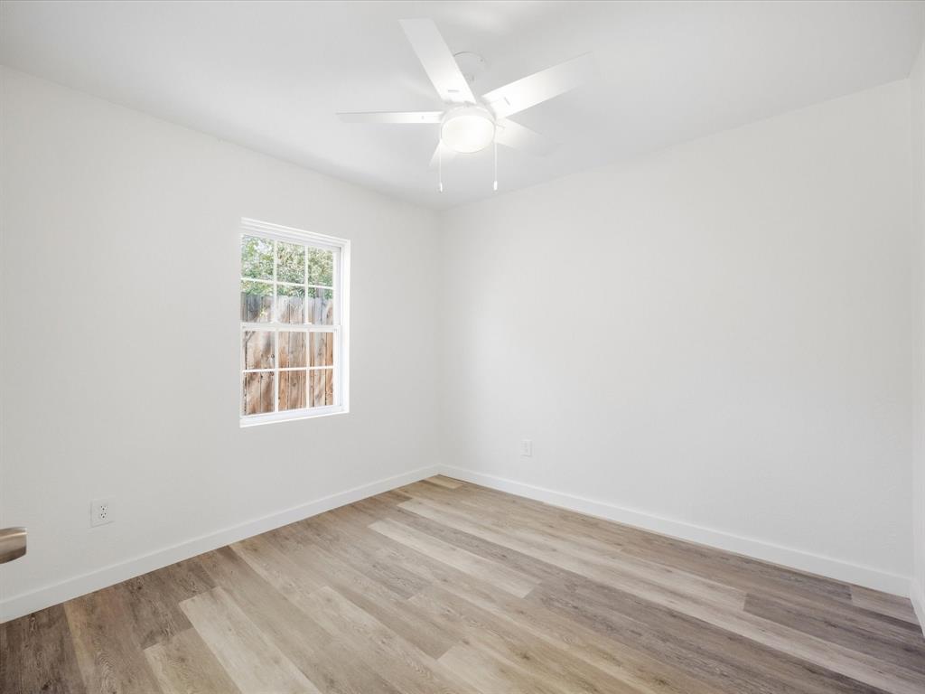 6933 Hatch Road Lake Worth, TX 76135 - Photo 16 of 28 White interior walls, wood-finish flooring, white ceiling fan, and a multi-pane window