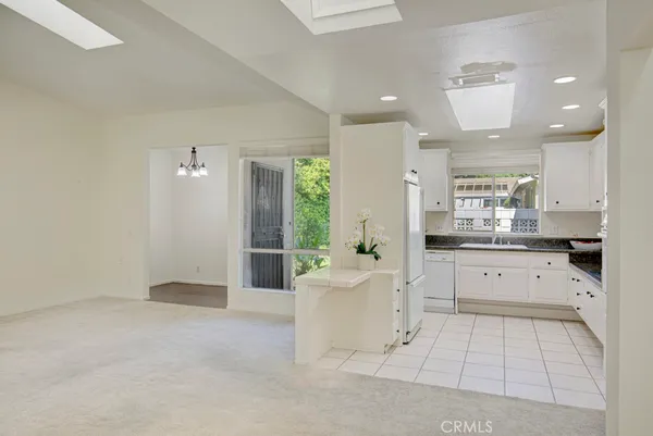 a kitchen with granite countertop white cabinets and white appliances
