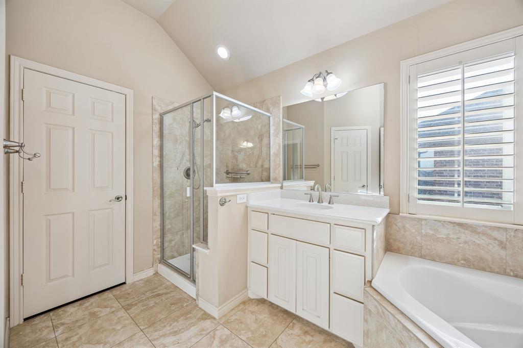 676 Scenic Ranch Circle Fairview, TX 75069 - Photo 15 of 30 a bathroom with a bathtub a double vanity sink a vanity a window and a mirror