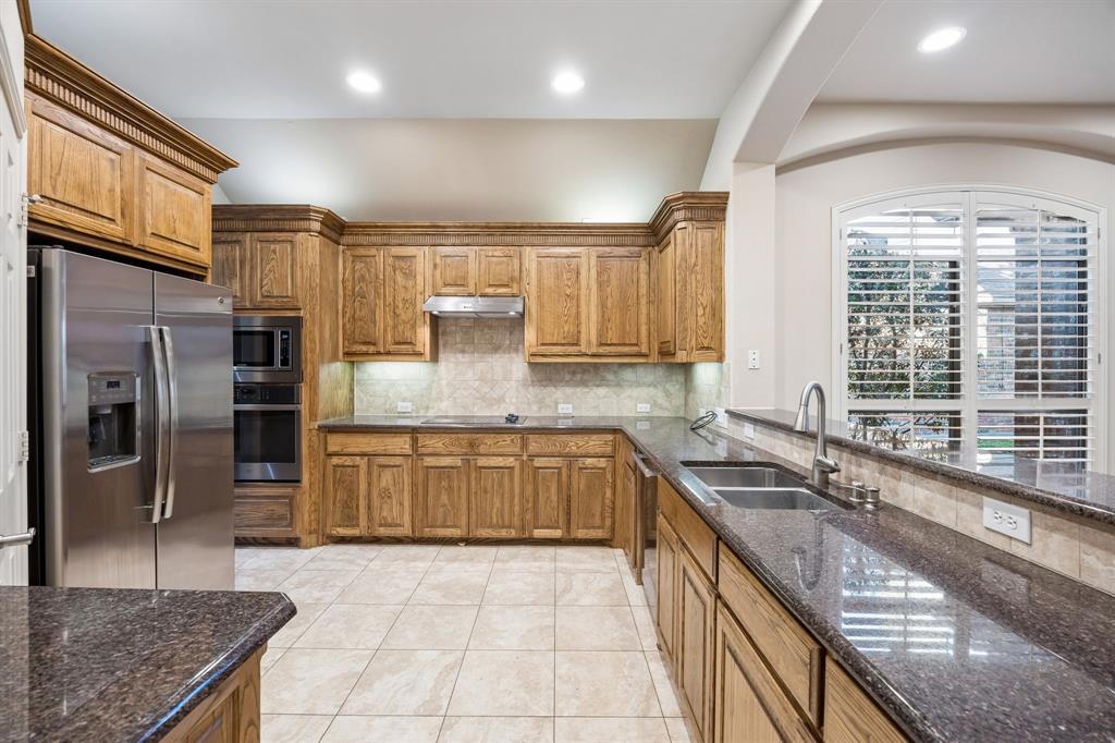 676 Scenic Ranch Circle Fairview, TX 75069 - Photo 7 of 30 a kitchen with stainless steel appliances granite countertop a sink stove and cabinets