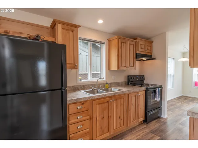 a kitchen with a refrigerator a stove and wooden cabinets