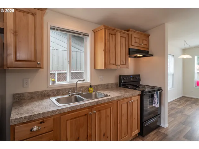a kitchen with stainless steel appliances granite countertop a sink stove and cabinets