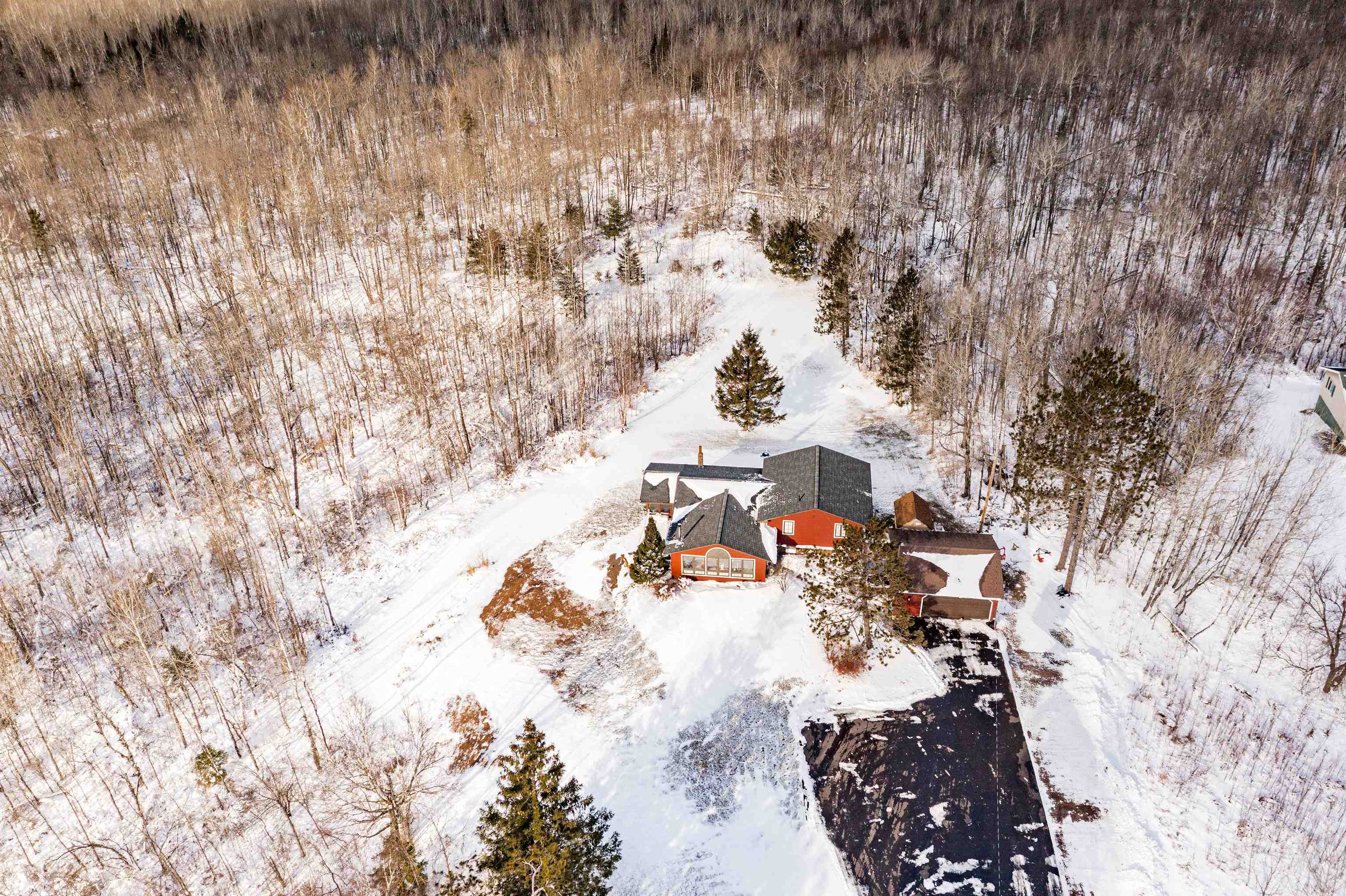 3325 Strand Road Duluth, MN 55803 - Photo 4 of 33 View of snowy & aerial view of home nestled in a private wooded setting accommodated with an asphalt driveway.